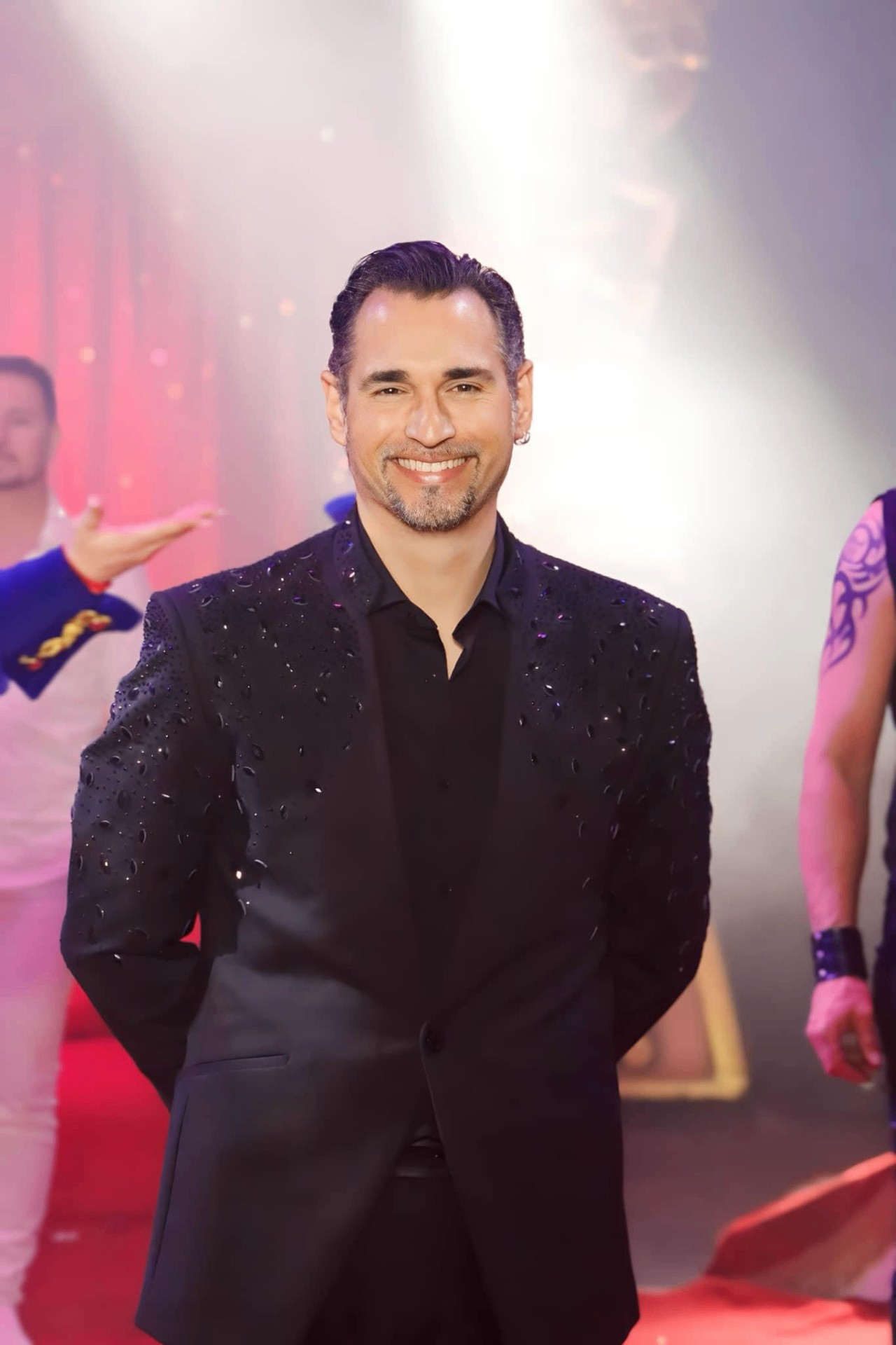 Nicolas Bouglione, veste noire ornée de strass, saluant le public en piste aux côtés des autres artistes