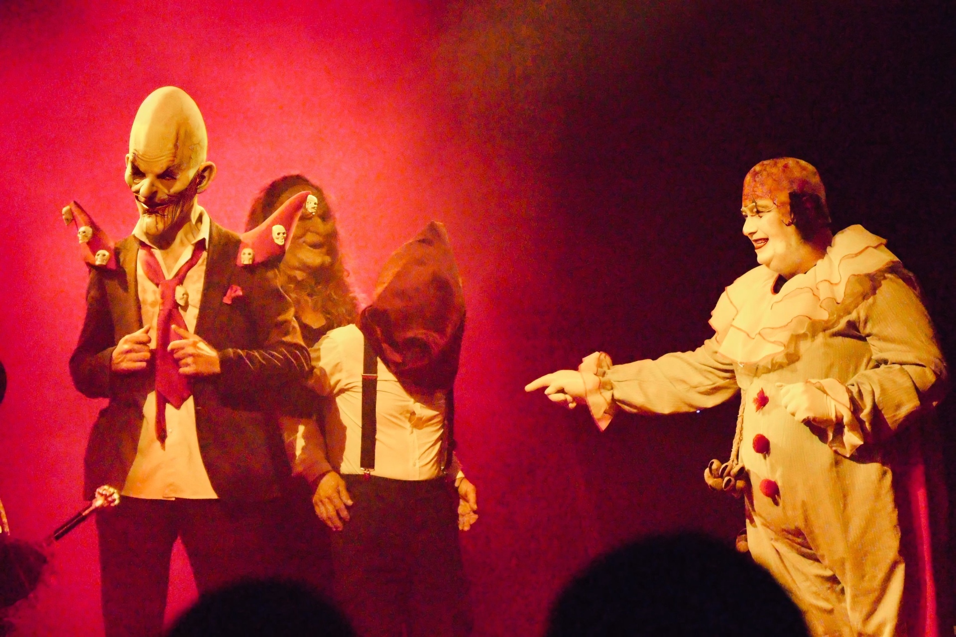 Personnages masqués et clowns du Horror Circus sur la piste rouge