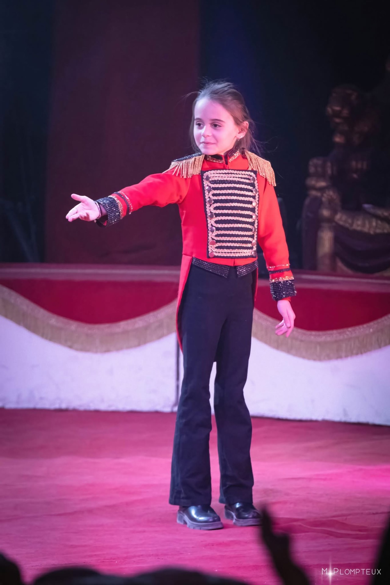 Alexa Bouglione saluant le public dans sa veste rouge et or